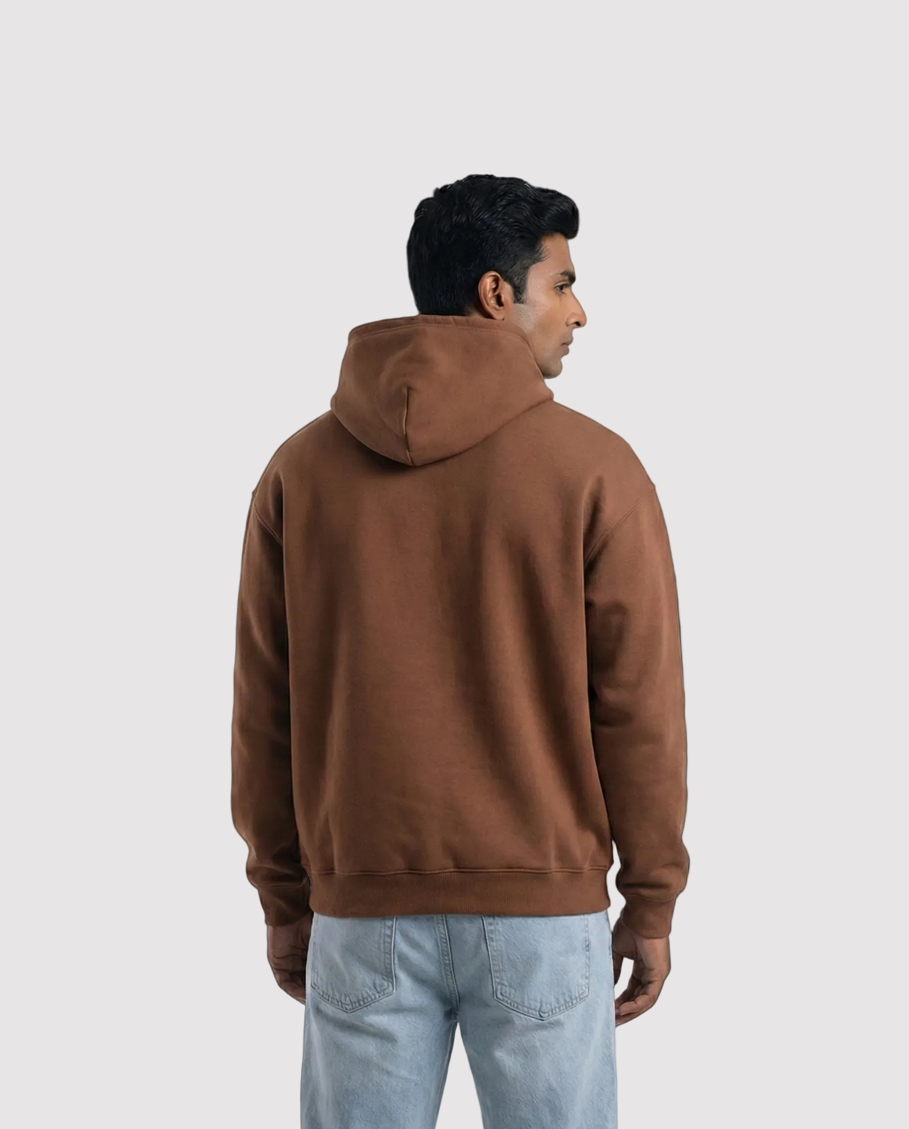 Man wearing a brown hoodie from behind on a light gray background