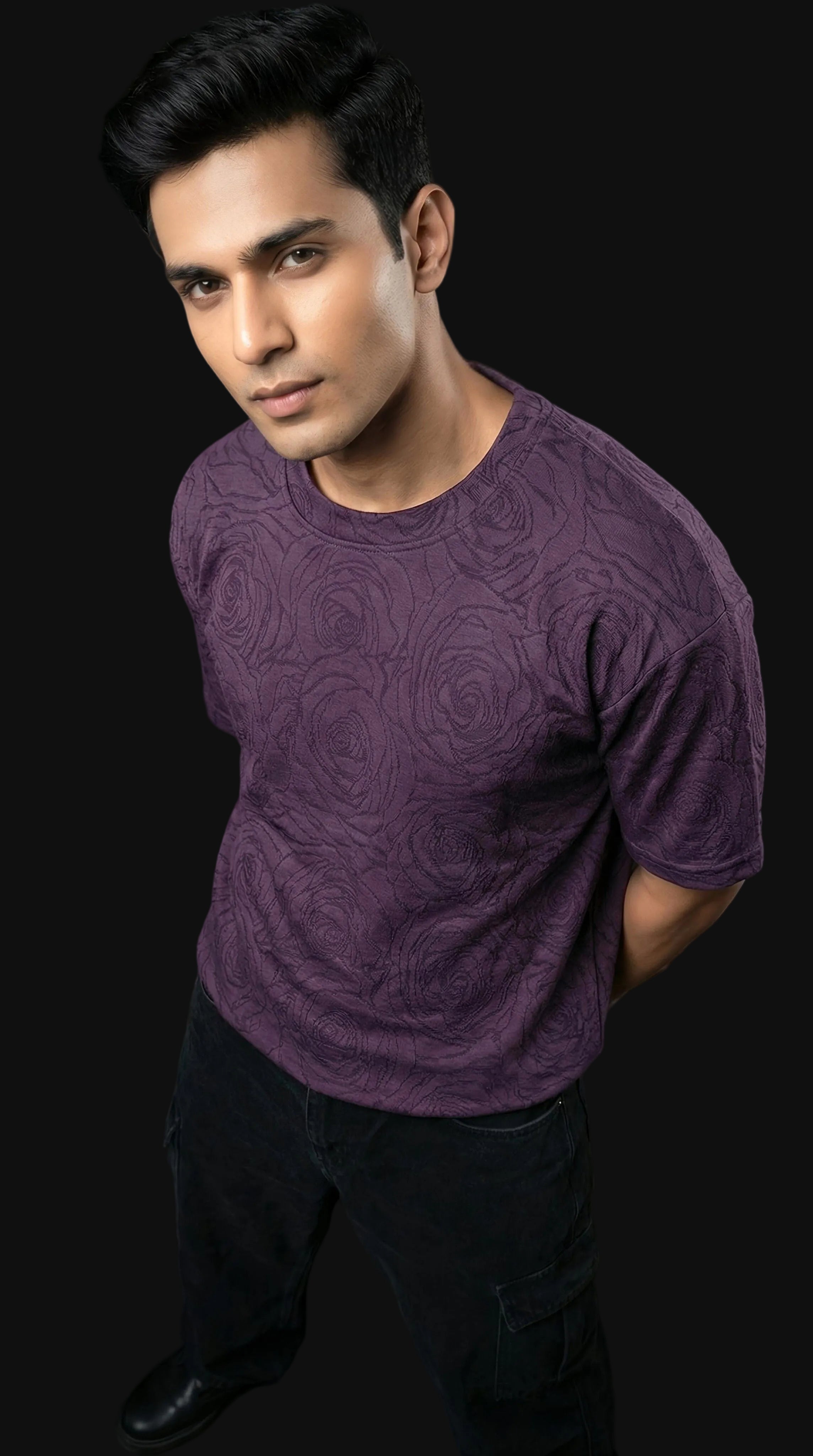 Man wearing a purple textured shirt against a black background