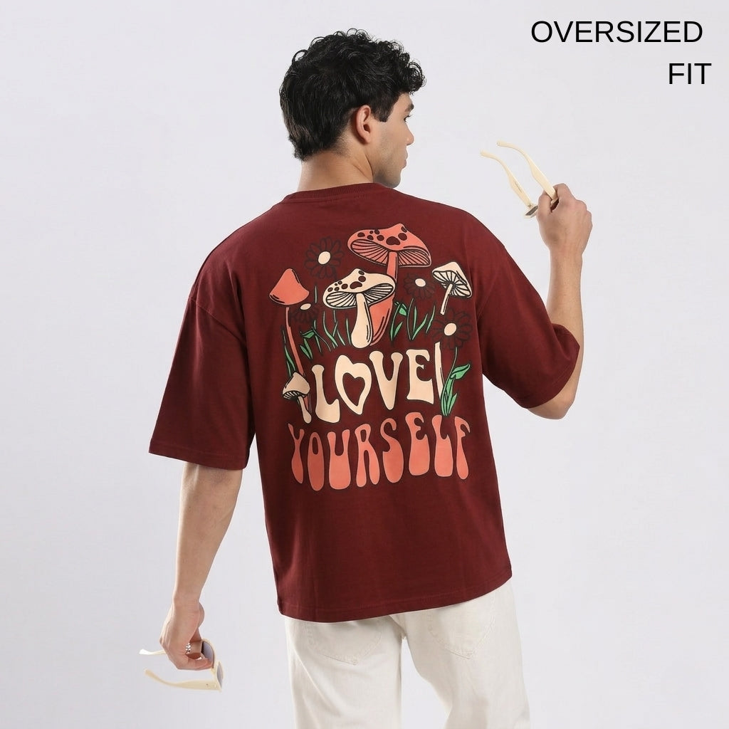 Person wearing an oversized maroon t-shirt with a graphic design on the back, holding chopsticks.