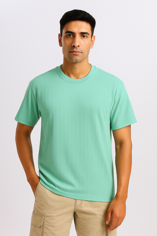Man wearing a cyan ribbed oversized T-shirt, shown from the front with hands in pockets.