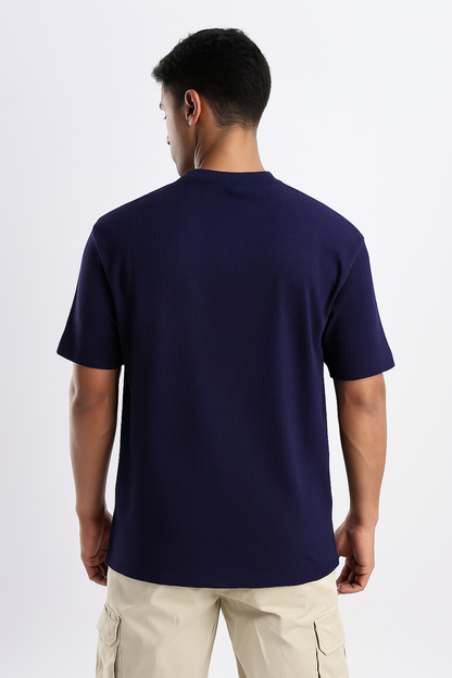 Man wearing a dark blue ribbed ultra stretch T-shirt, shown from the back