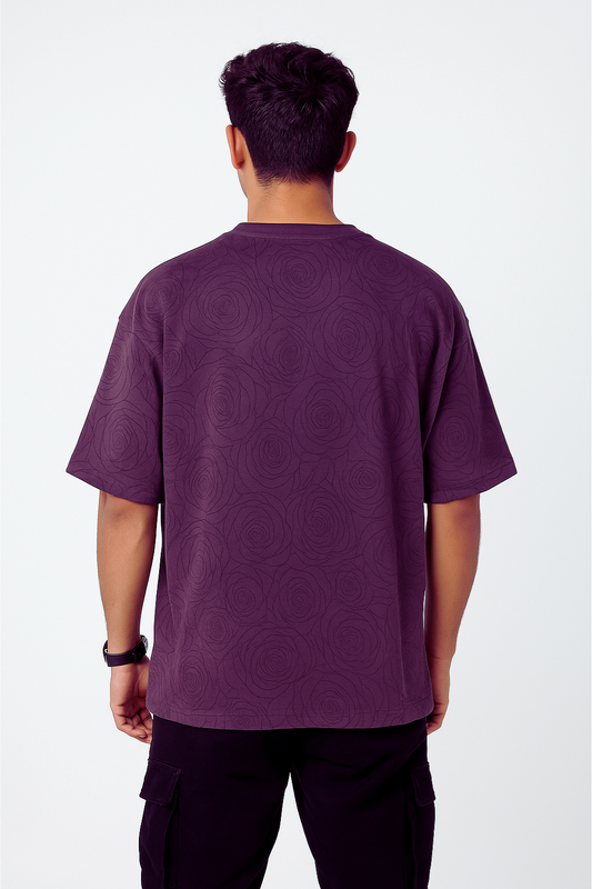 Man wearing a purple drop shoulder T-shirt with an embossed rose design, shown from the back.